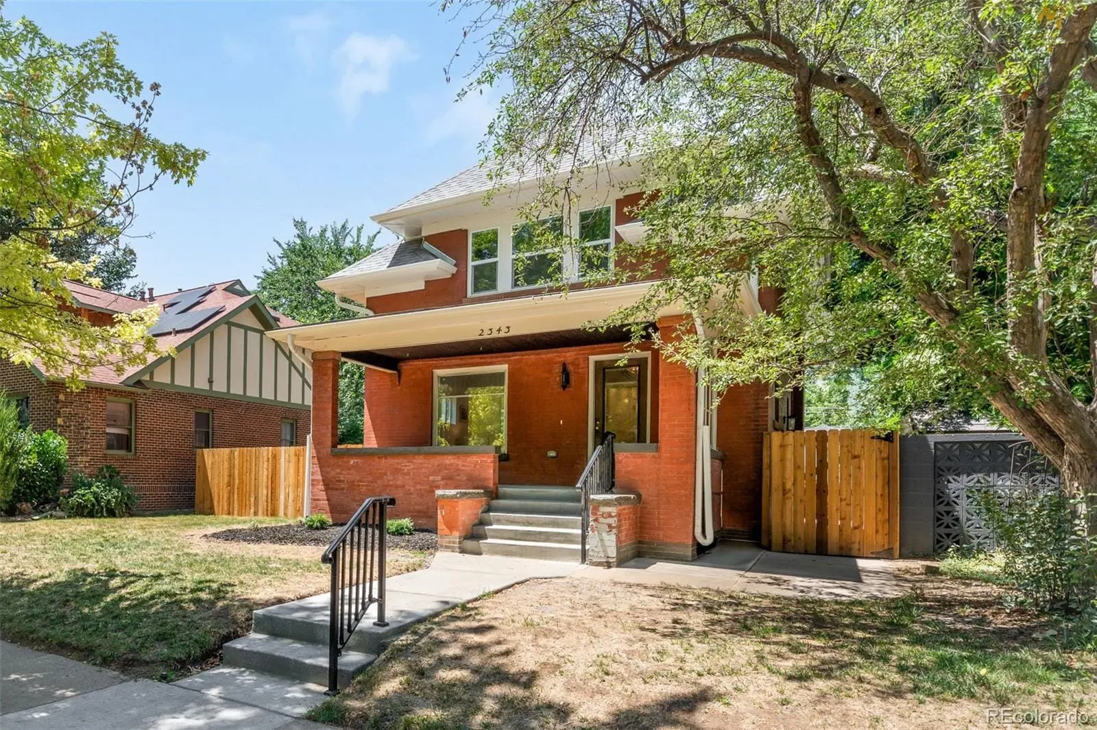 A view of a house with a yard and wooden fence at 2343 Dahlia Street