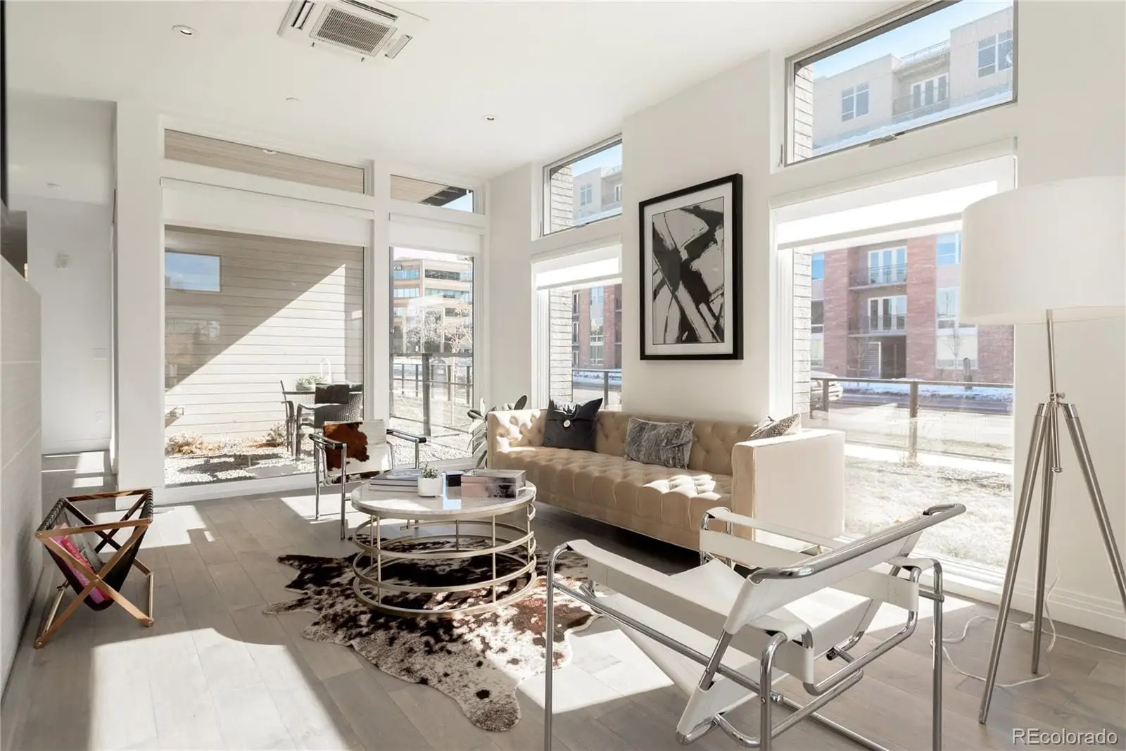 A living room with patio furniture and a large window at 274 South Monroe Street, Unit 1002