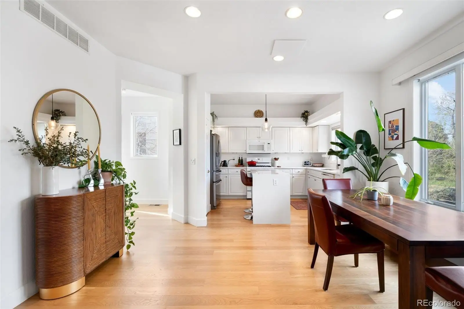A living room with kitchen island furniture and a potted plant at 234 South Madison Street, Unit H