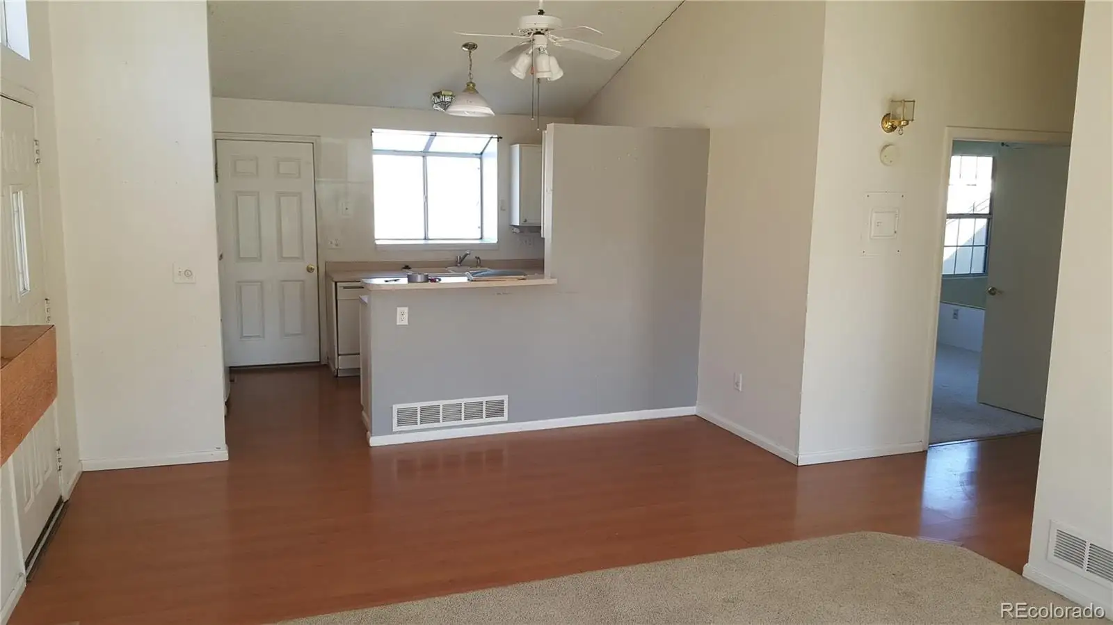 An empty room with wooden floor and windows at 17155 East Chenango Avenue, Unit A