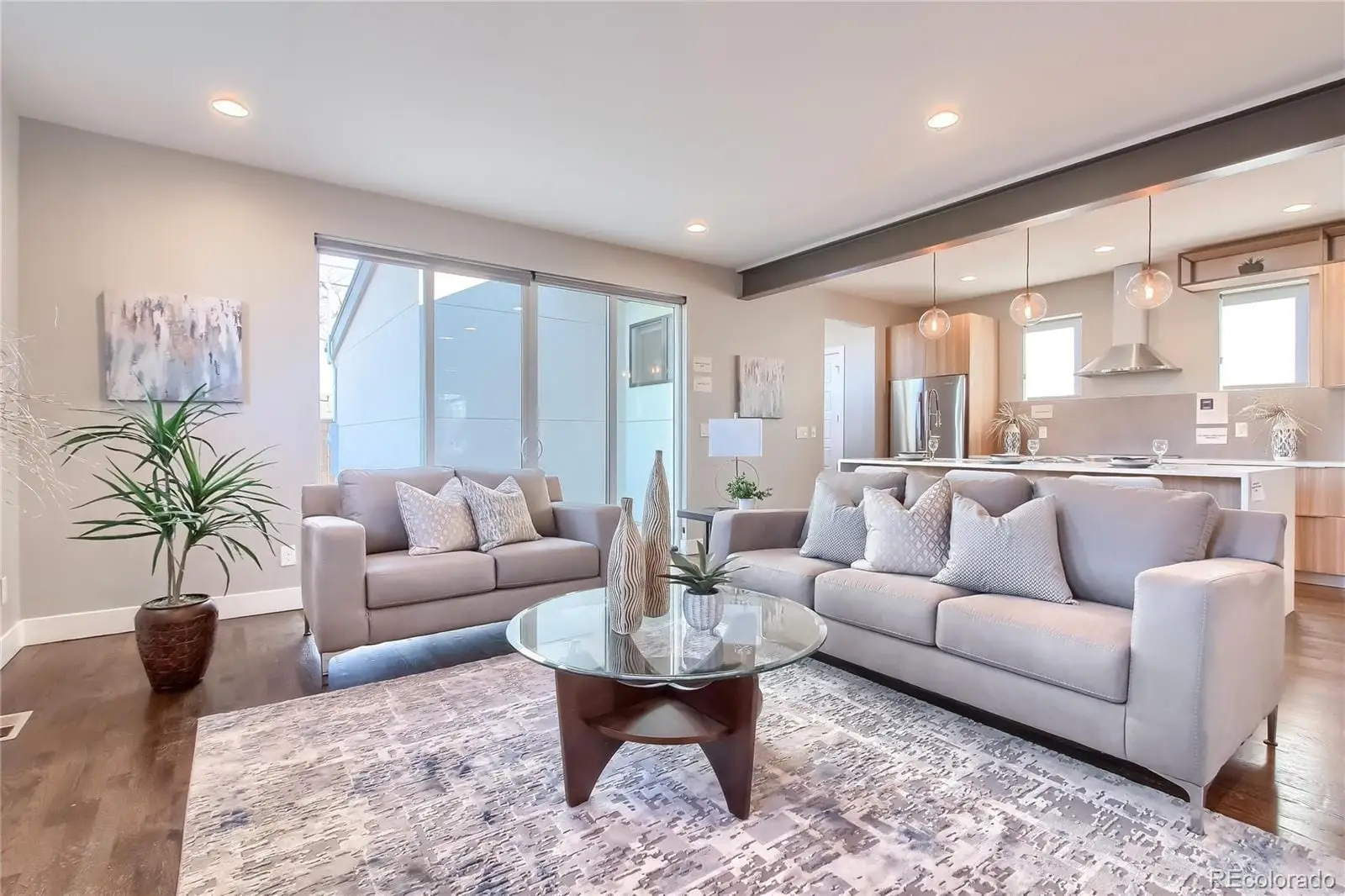 A living room with furniture potted plant and a large window at 3000 Glencoe Street