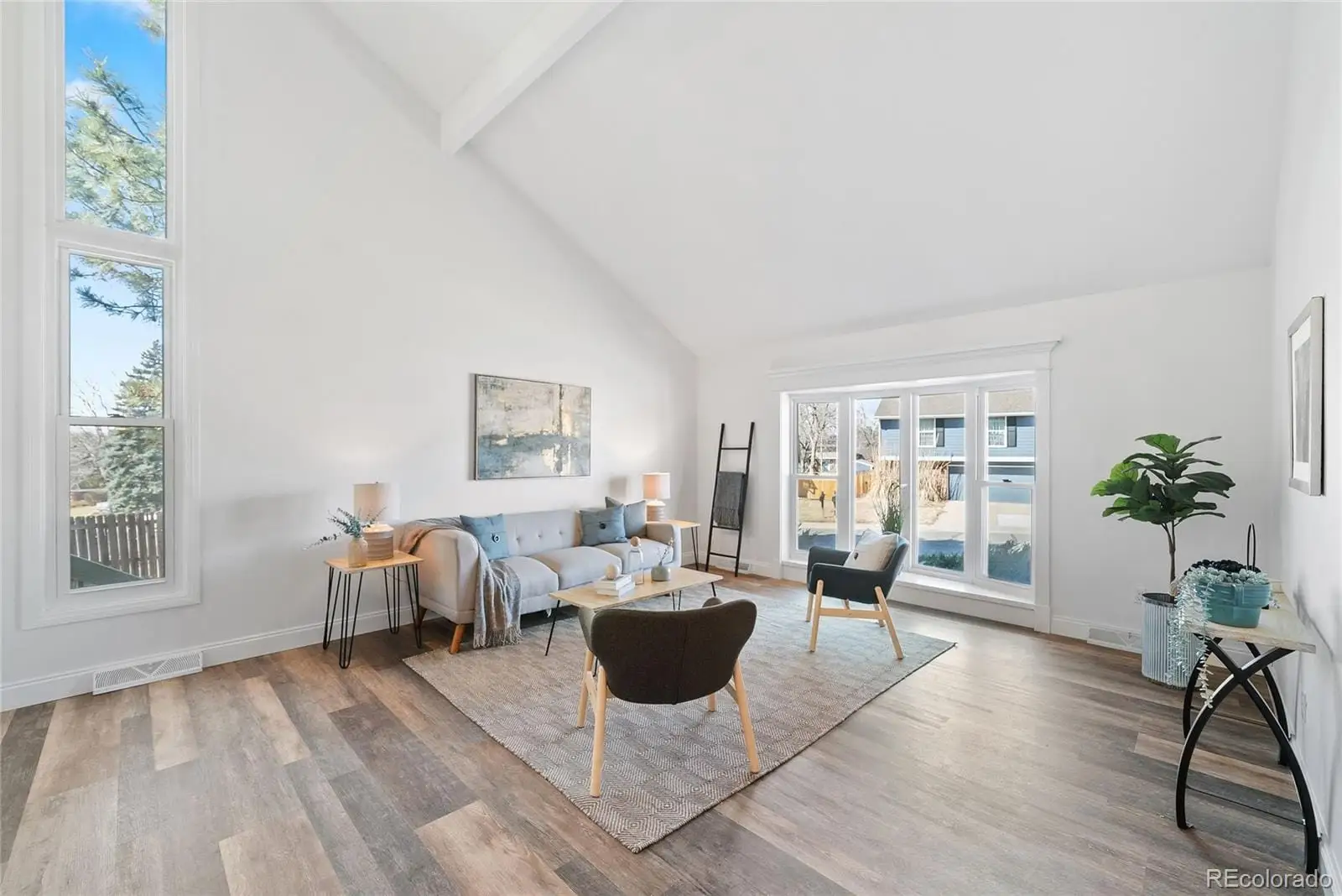 A living room with furniture wooden floor and a potted plant at 8876 East Phillips Place