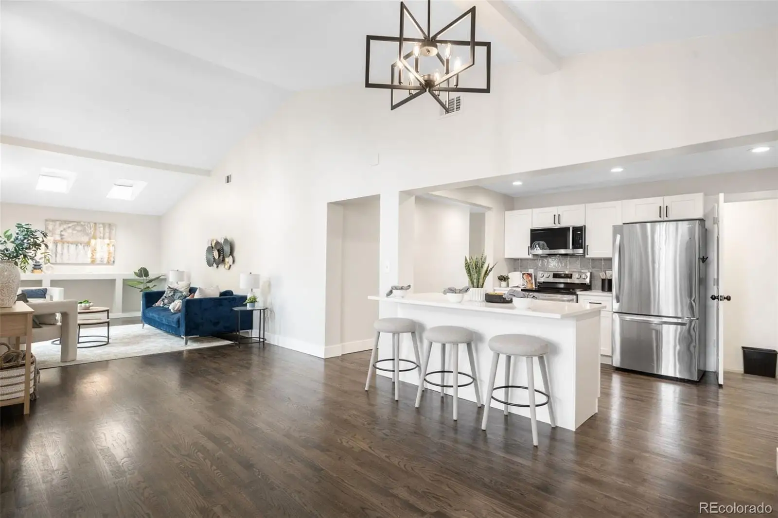 A kitchen with stainless steel appliances a dining table chairs refrigerator and microwave at 7901 Maria Street