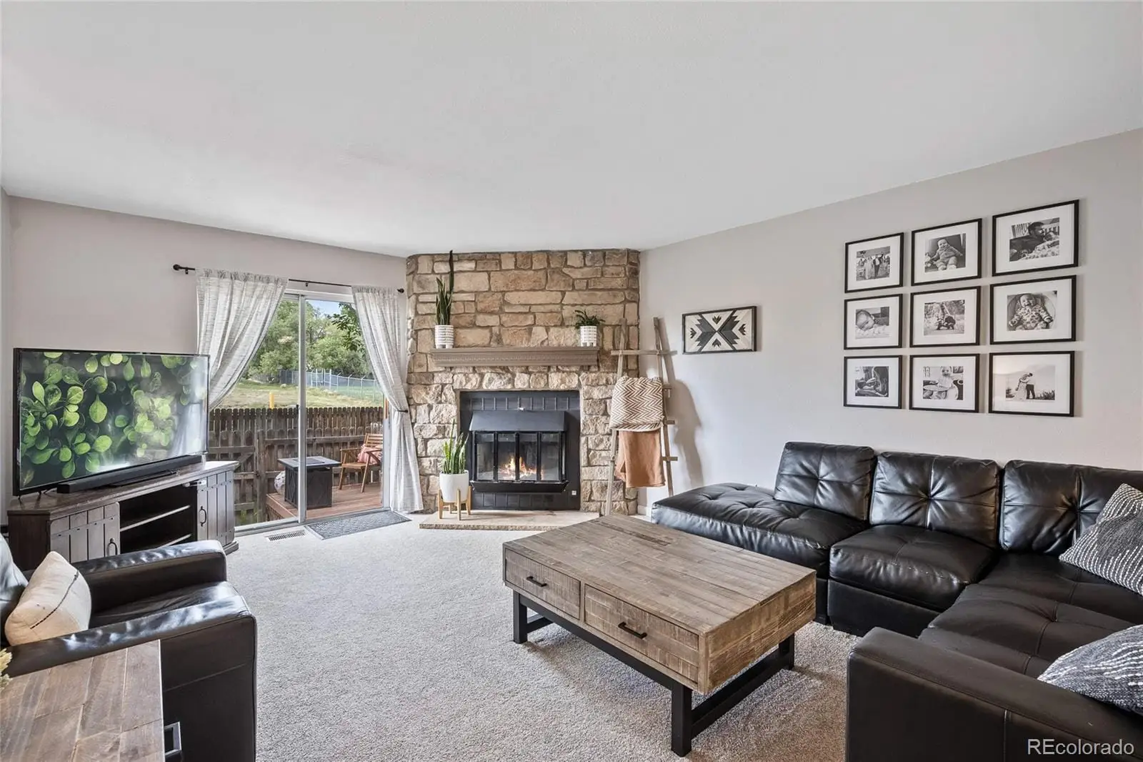 A living room with furniture a flat screen tv and a fireplace at 8135 South Fillmore Circle