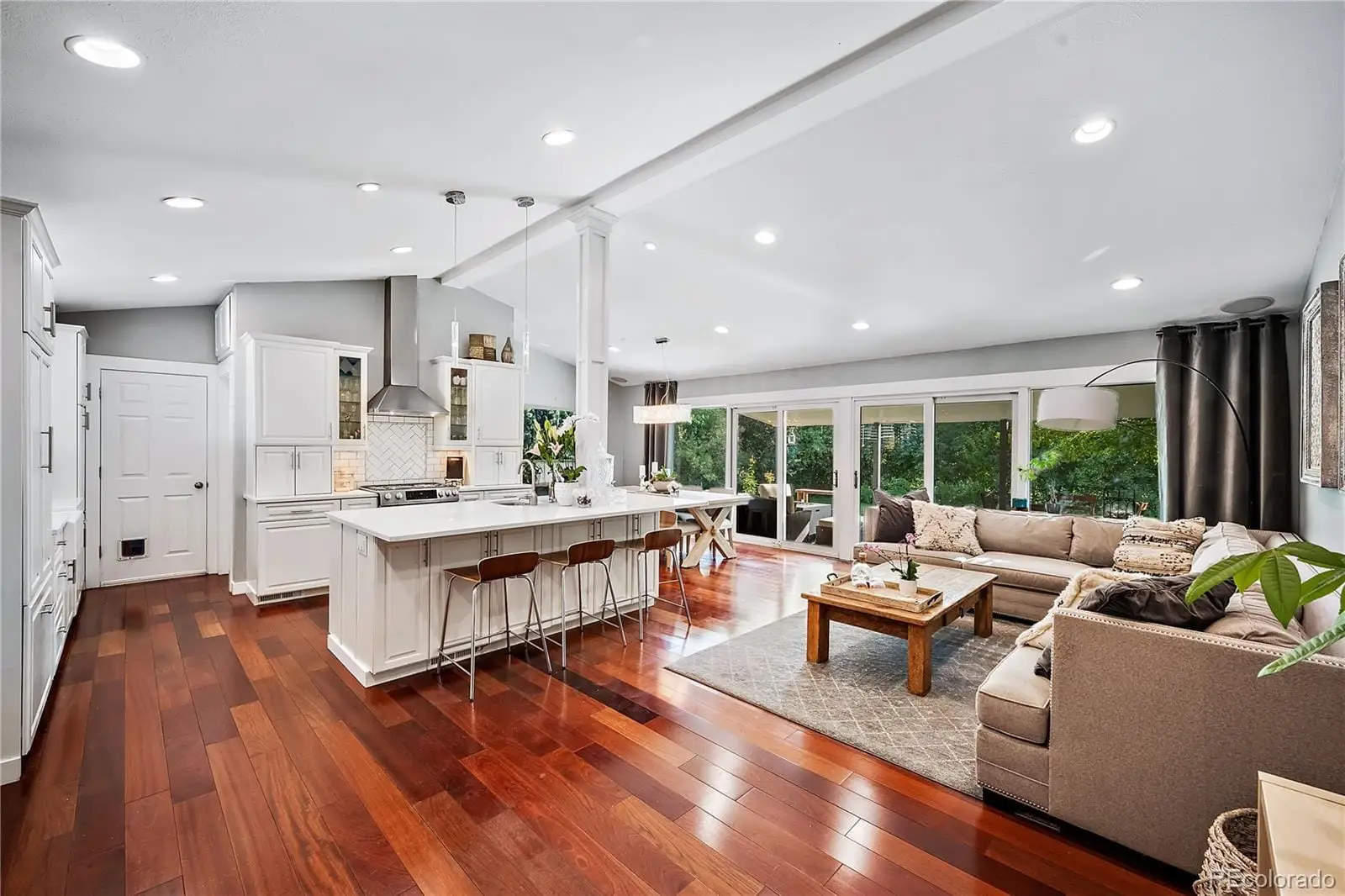 A living room with kitchen island granite countertop wooden floor and a large window at 708 South Grape Street