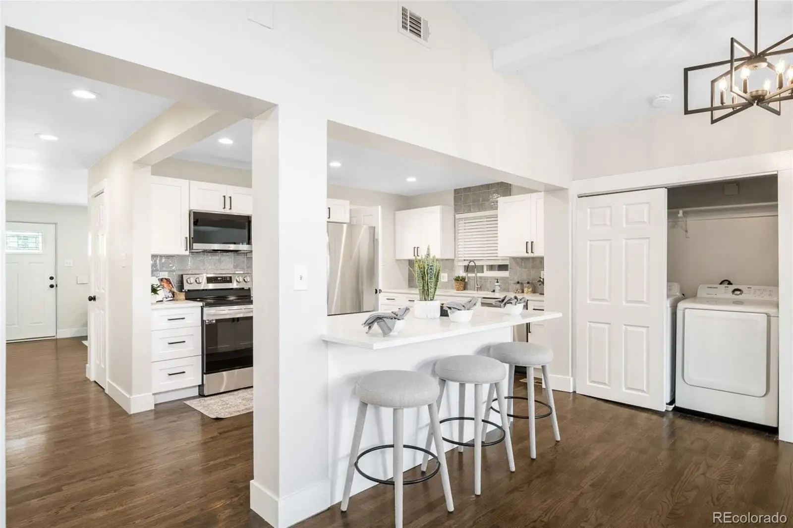 A kitchen with stainless steel appliances kitchen island granite countertop a refrigerator and a stove top oven at 7901 Maria Street