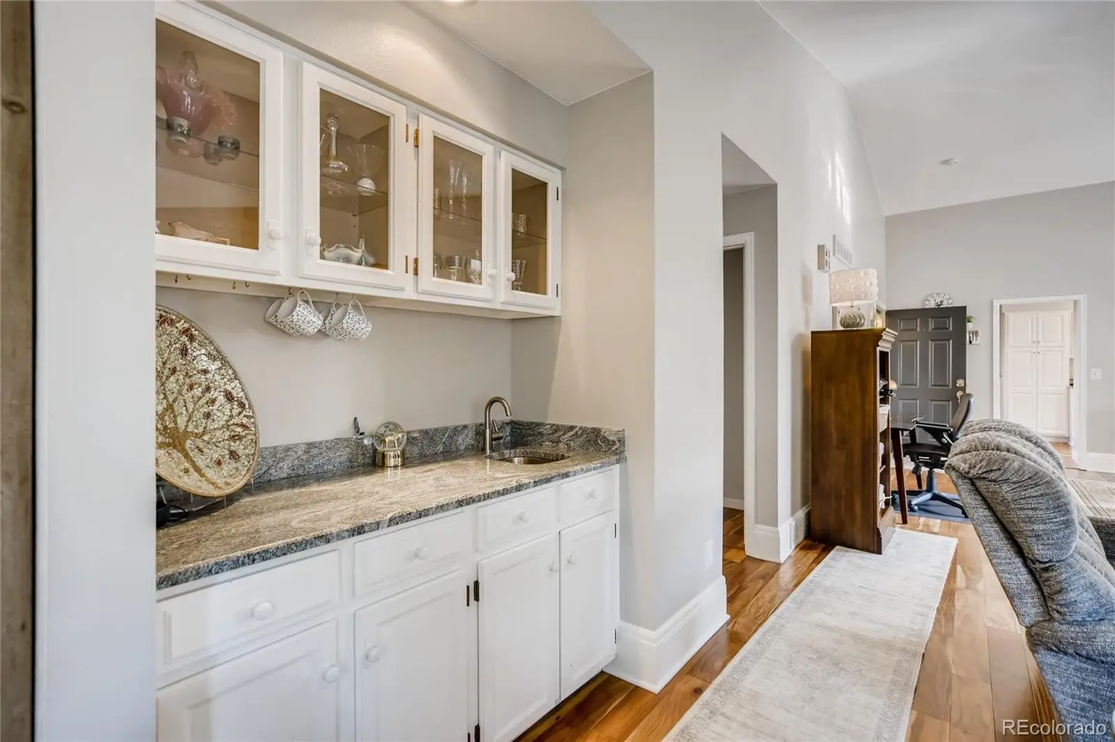 A spacious bathroom with a granite countertop sink and a mirror at 7553 West Euclid Drive