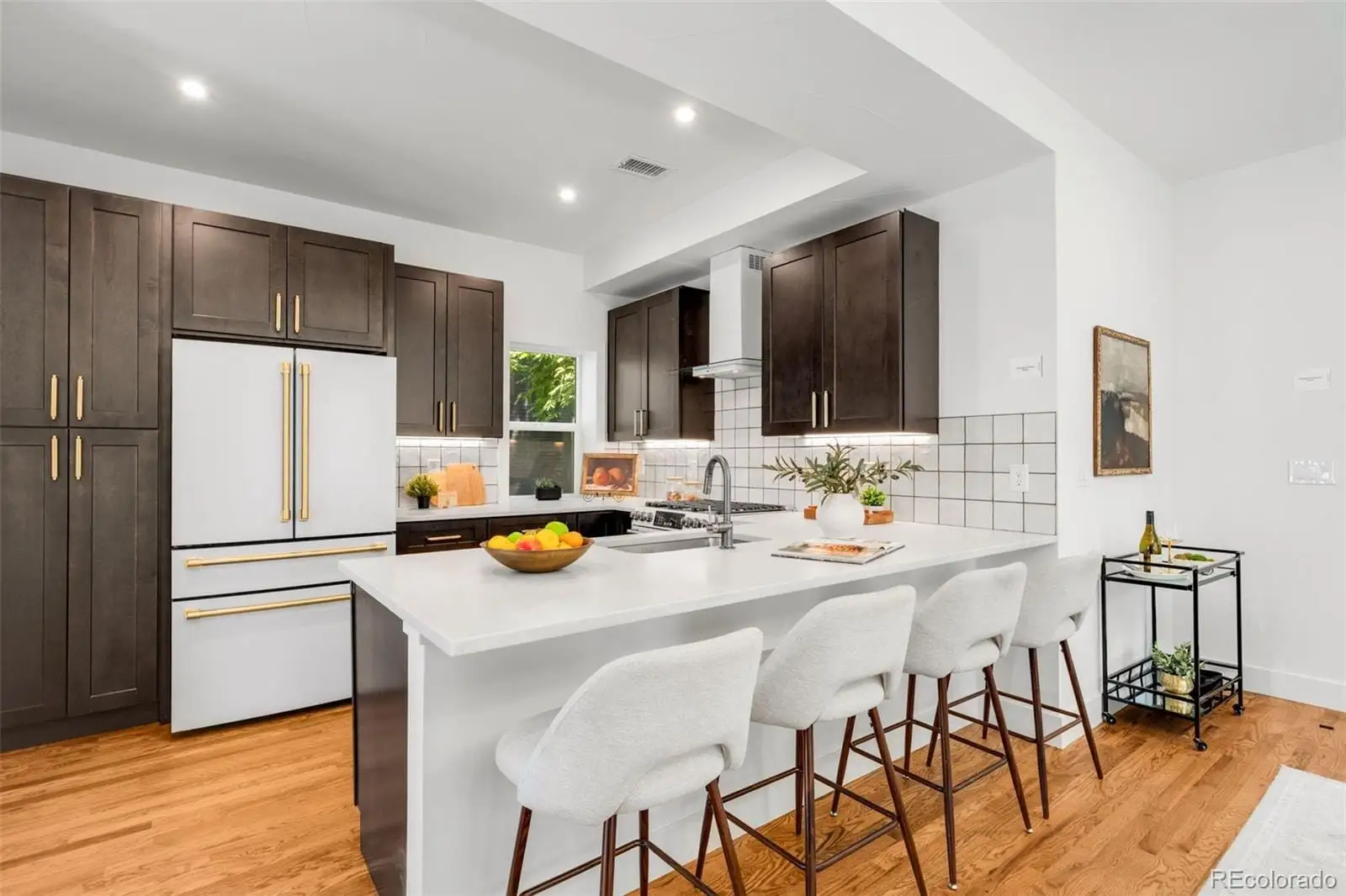 A kitchen with granite countertop a refrigerator and a stove top oven at 2343 Dahlia Street
