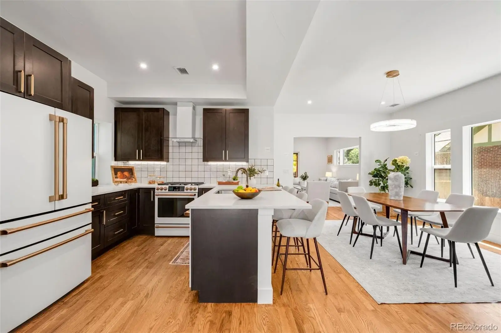 A living room with stainless steel appliances granite countertop furniture wooden floor and a view of kitchen at 2343 Dahlia Street