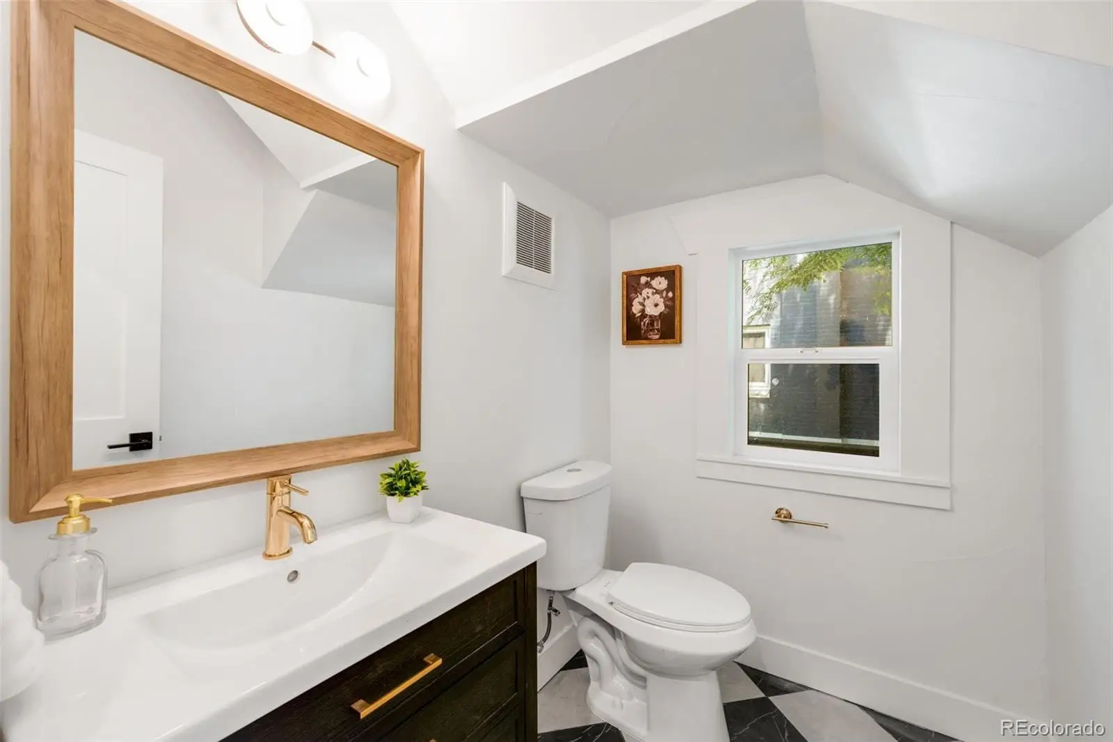A bathroom with a sink toilet and a mirror at 2343 Dahlia Street